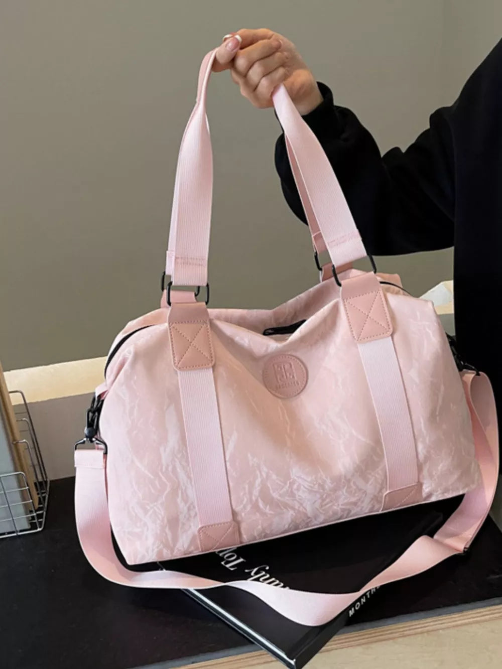 Chic medium blush pink Oxford cloth travel bag with textured finish and dual straps.