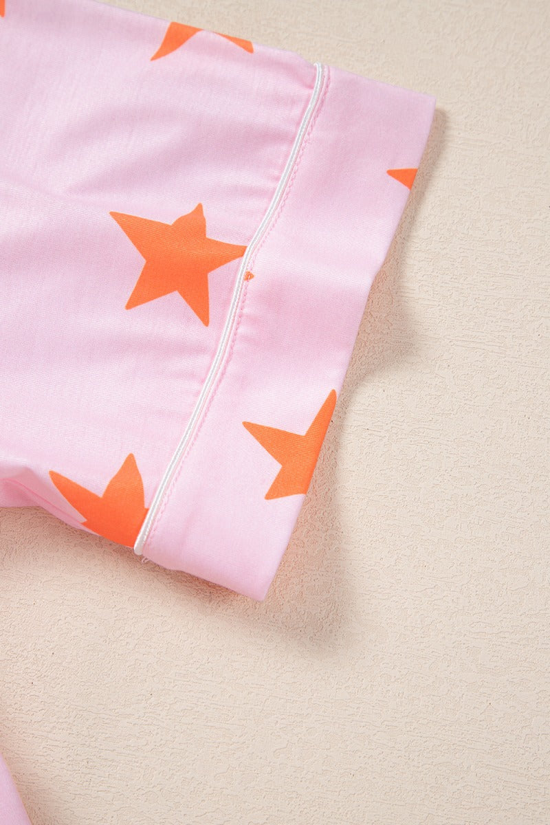 Blush pink pajama top with orange stars and white piping detail.