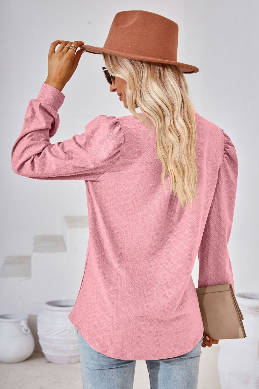 Pink textured bishop sleeve blouse with puff shoulders.