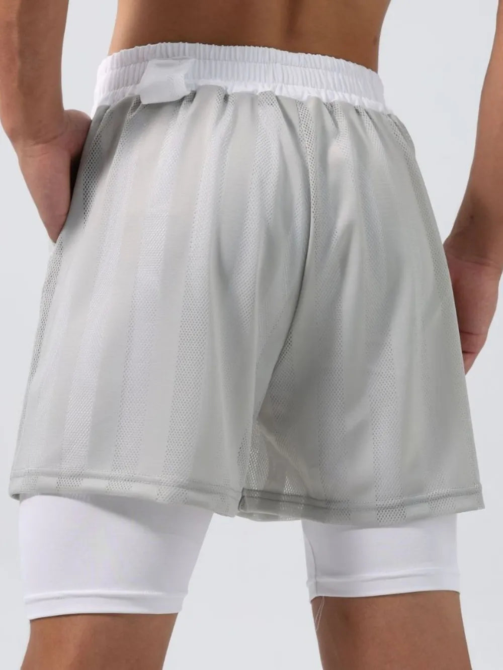 Gray layered mesh performance shorts with white compression liner and striped texture.