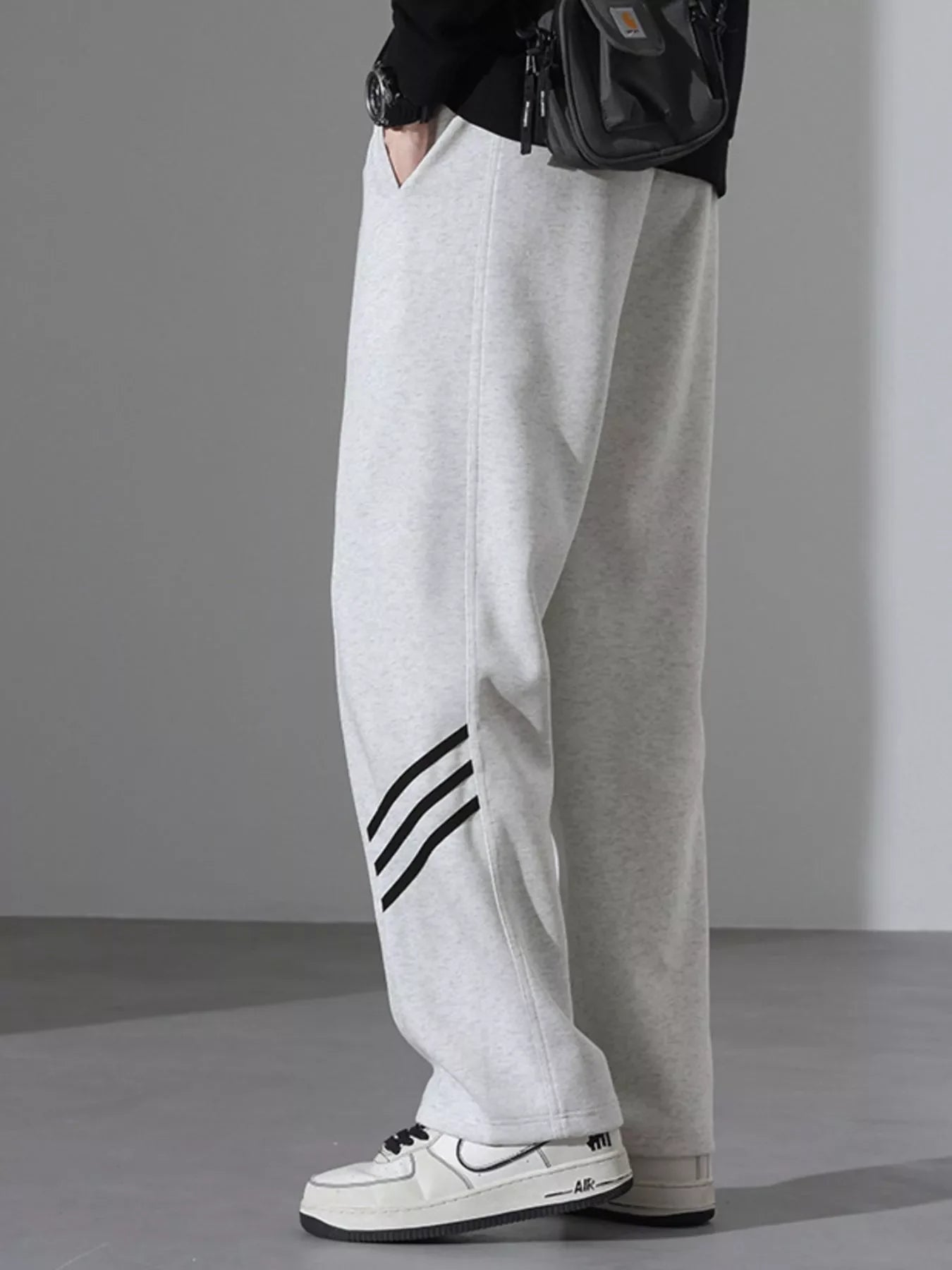 Light Flower Gray sweatpants with black stripes detail and loose fit.