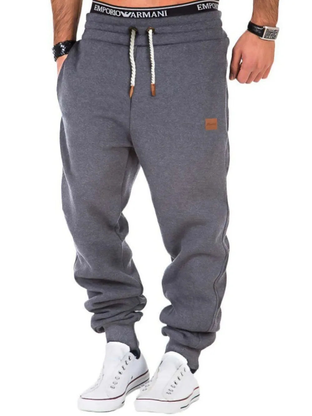 Gray relaxed fit joggers with leather detail and drawstring waist.