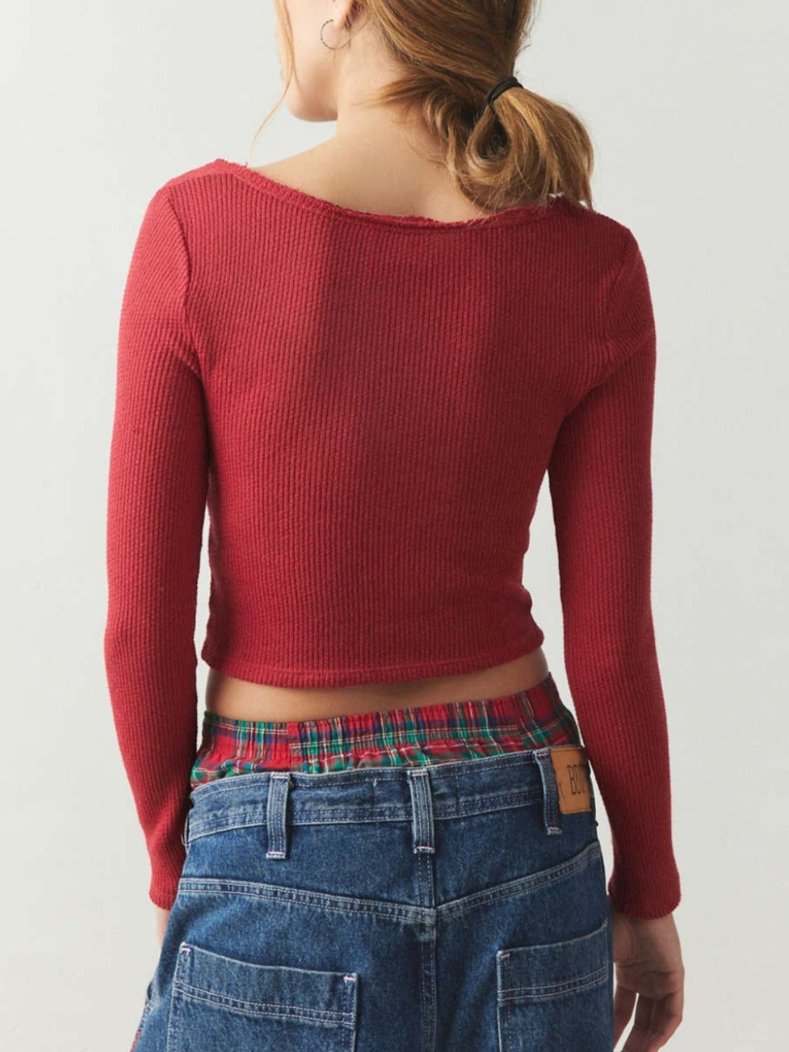 Burgundy ribbed crop top with distressed neckline and long sleeves.