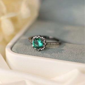Elegant sterling silver ring with a green zircon center stone and halo of small diamonds.