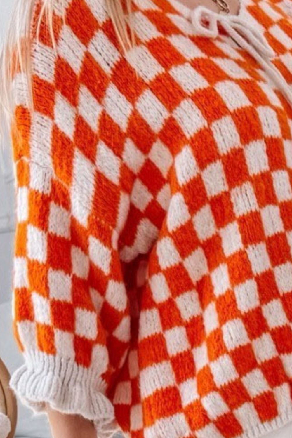 Orange and white checkered knit cardigan with tie front and ruffle sleeves
