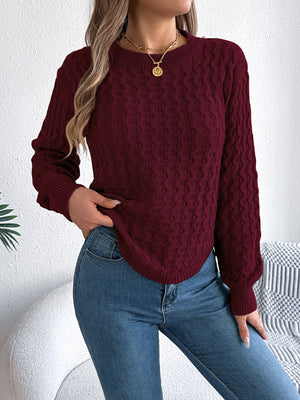 Burgundy acrylic cable knit sweater with asymmetric hem and crew neck.
