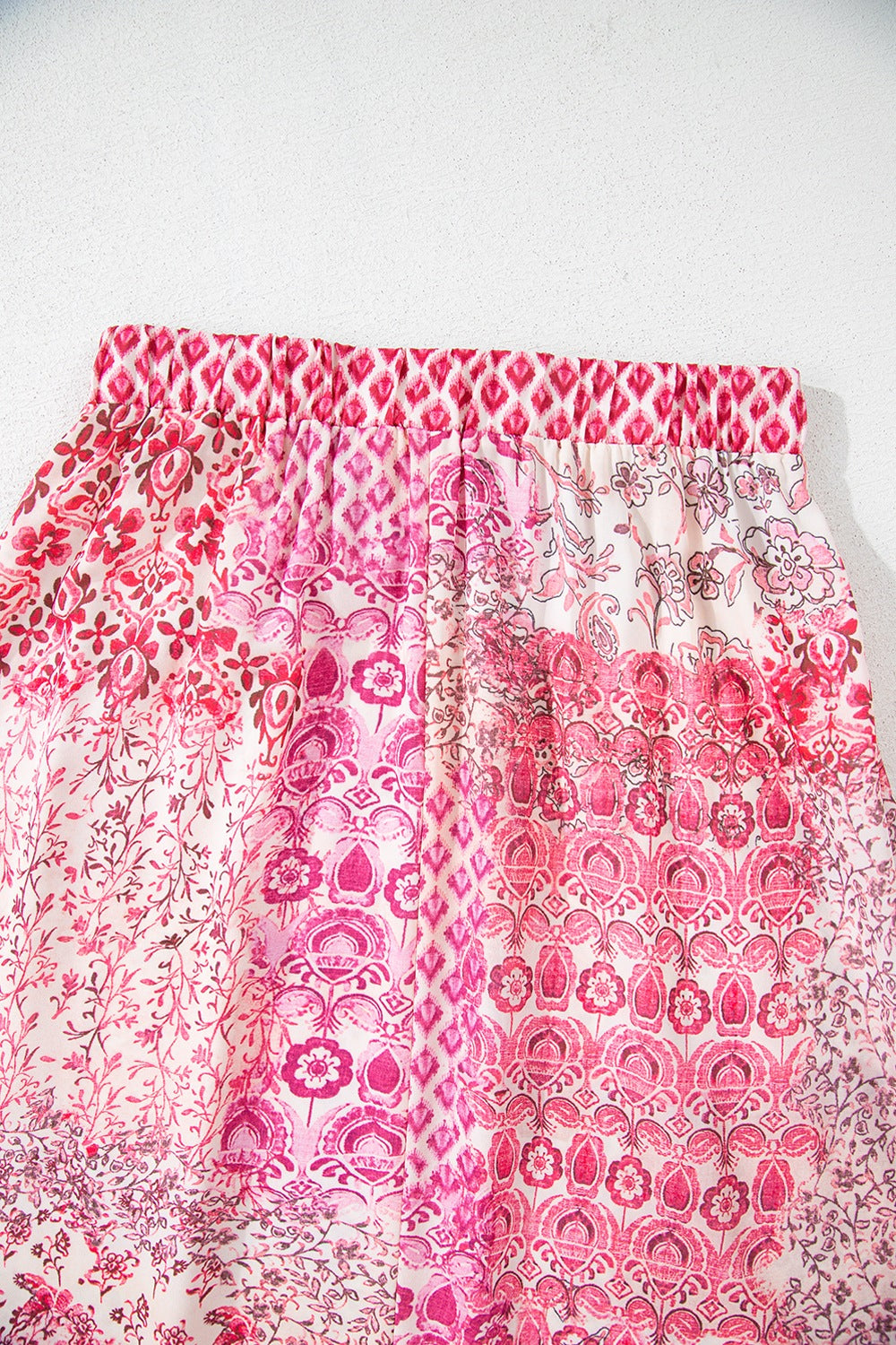 Printed tiered maxi skirt in dusty pink with a patchwork floral and geometric design.