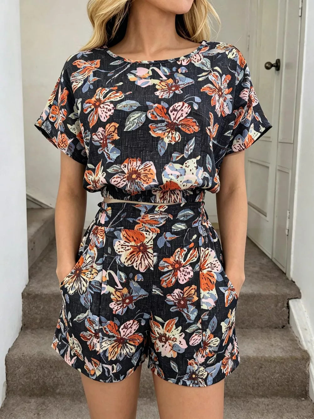 Floral two-piece set in navy blue with crop top and shorts featuring pockets.