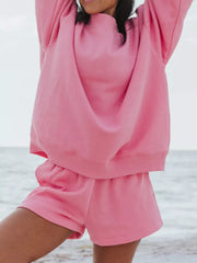 Pink crew neck sweatshirt and shorts set for women, comfortable loungewear.