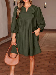 Olive green polyester mini dress with scalloped V-neck, balloon sleeves, and pockets.
