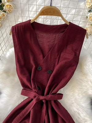 Burgundy V-neck sleeveless wide leg jumpsuit with double-breasted buttons and tie waist.