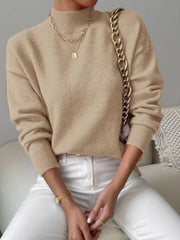 Khaki mock neck knit sweater with dropped shoulders, styled with layered necklaces.