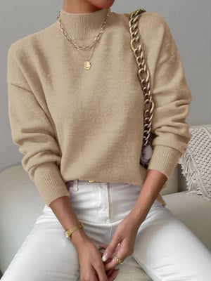 Khaki mock neck knit sweater with dropped shoulders, styled with layered necklaces.
