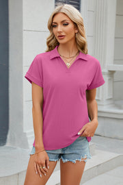 Textured hot pink polo top with cuffed short sleeves and a v-neck.