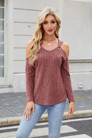 Ribbed cold-shoulder top in rust with ring detail and V-neck, paired with jeans.