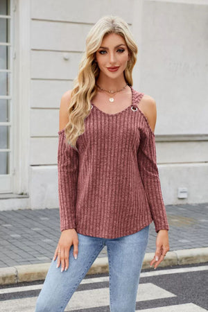 Ribbed cold-shoulder top in rust with ring detail and V-neck, paired with jeans.