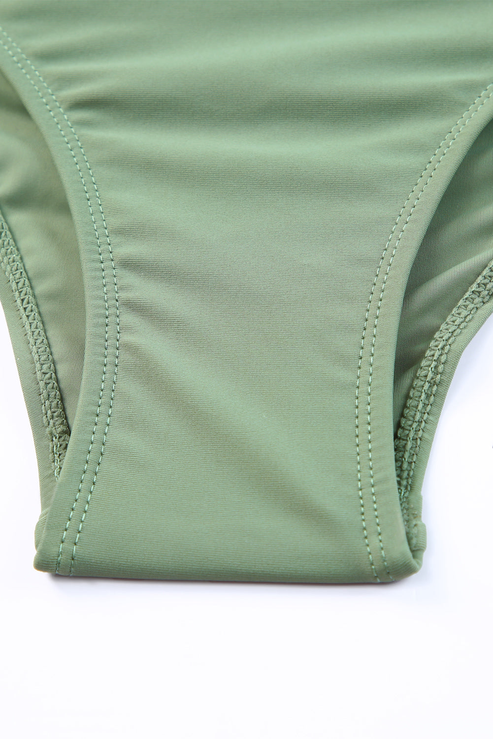 Sage ruched bodice halter swim dress detail showing stitching and fabric.