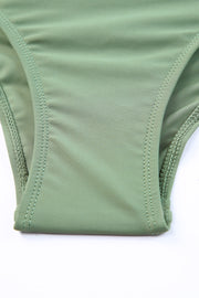Sage ruched bodice halter swim dress detail showing stitching and fabric.