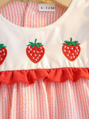Baby dress with embroidered strawberries and red ruffle trim on striped cotton fabric.