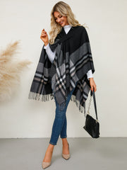 Black asymmetric plaid cape with fringe detail and a cross-over neckline.