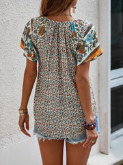 Bohemian floral print blouse with flutter sleeves and a gathered neckline, shown in multicolor.