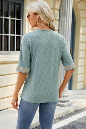 Light green textured V-neck top with lace trim on sleeves.