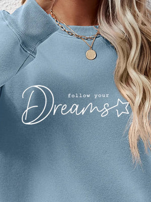 Misty Blue oversized sweatshirt with white script graphic that says "follow your Dreams" and a star detail.