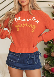 Orange knit sweater with "thanks giving" graphic, crew neck, and balloon sleeves.