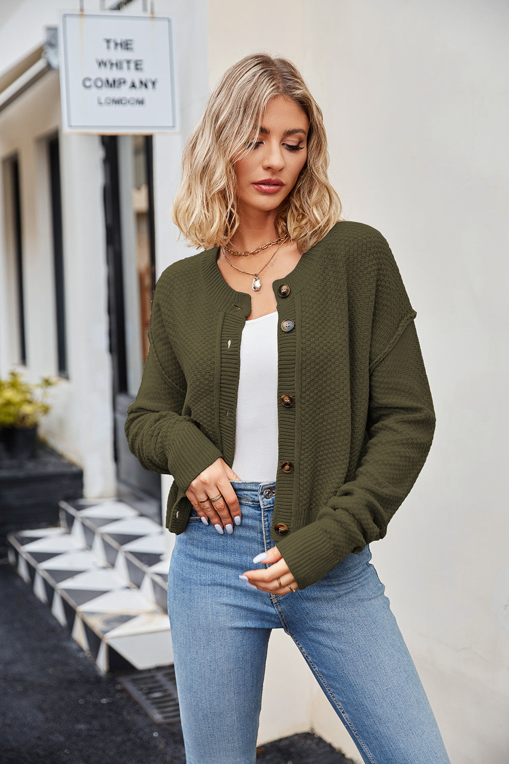Moss green textured knit cropped cardigan with buttons and round neckline.
