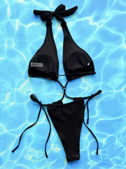Black textured halterneck cutout swimsuit with tie sides and a bow detail at the neck.