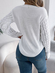 White acrylic knit sweater with textured cable sleeves and asymmetric hem