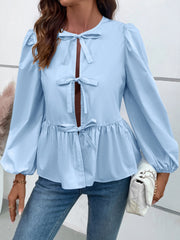 Light blue peplum blouse with keyhole neckline and tie details, long puff sleeves.