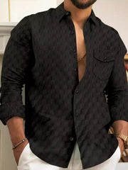 Textured black cotton button-up shirt with two chest pockets and button cuffs.