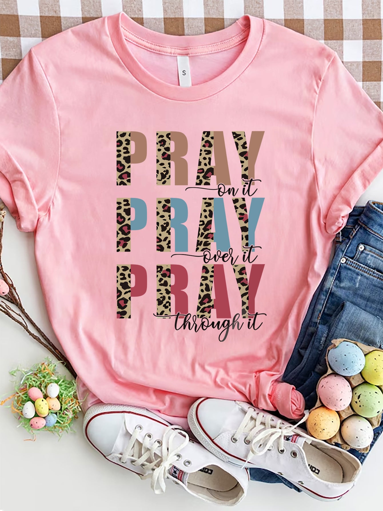 Textured graphic t-shirt in blush pink with "PRAY on it, PRAY over it, PRAY through it" text and leopard print accents.