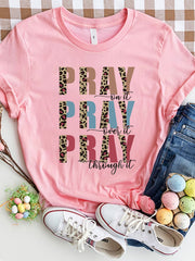 Textured graphic t-shirt in blush pink with "PRAY on it, PRAY over it, PRAY through it" text and leopard print accents.