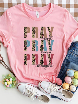 Textured graphic t-shirt in blush pink with "PRAY on it, PRAY over it, PRAY through it" text and leopard print accents.