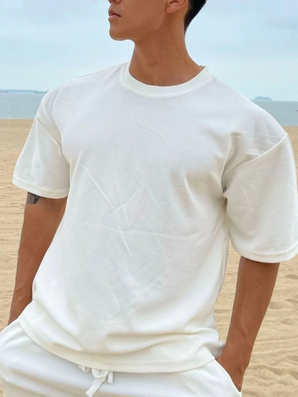 Oversized white cotton tee with drop shoulder and crew neck.