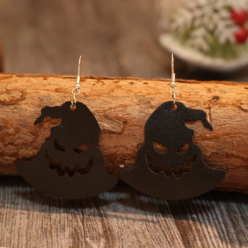 Black leather witch hat earrings with carved jack-o-lantern faces.