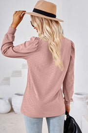 Blush pink diamond-textured puff sleeve top with a round neckline.