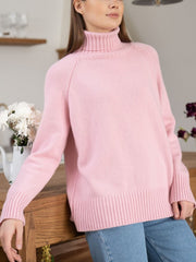 Blush pink cashmere turtleneck sweater with raglan sleeves and ribbed cuffs and hem.