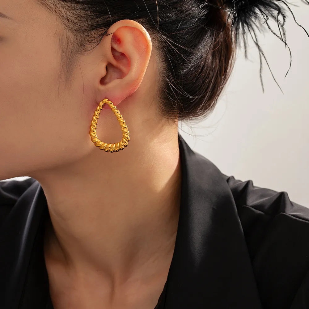 Gold rope-textured teardrop hoop earrings with a twisted design.