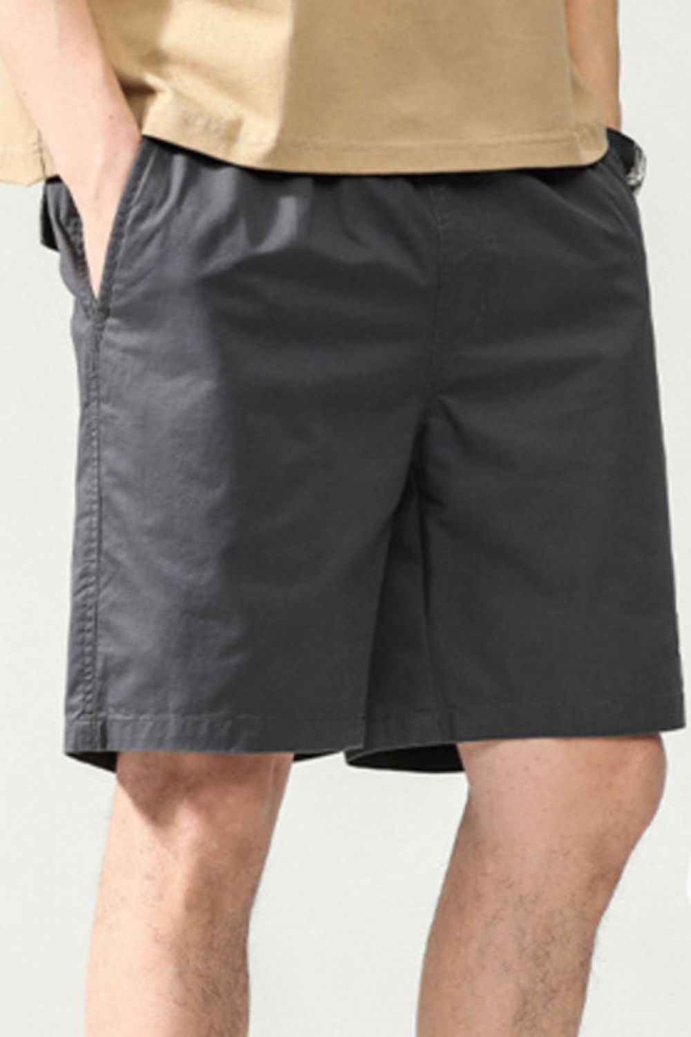 Dark gray chino shorts with elastic waist and pockets, above the knee length.