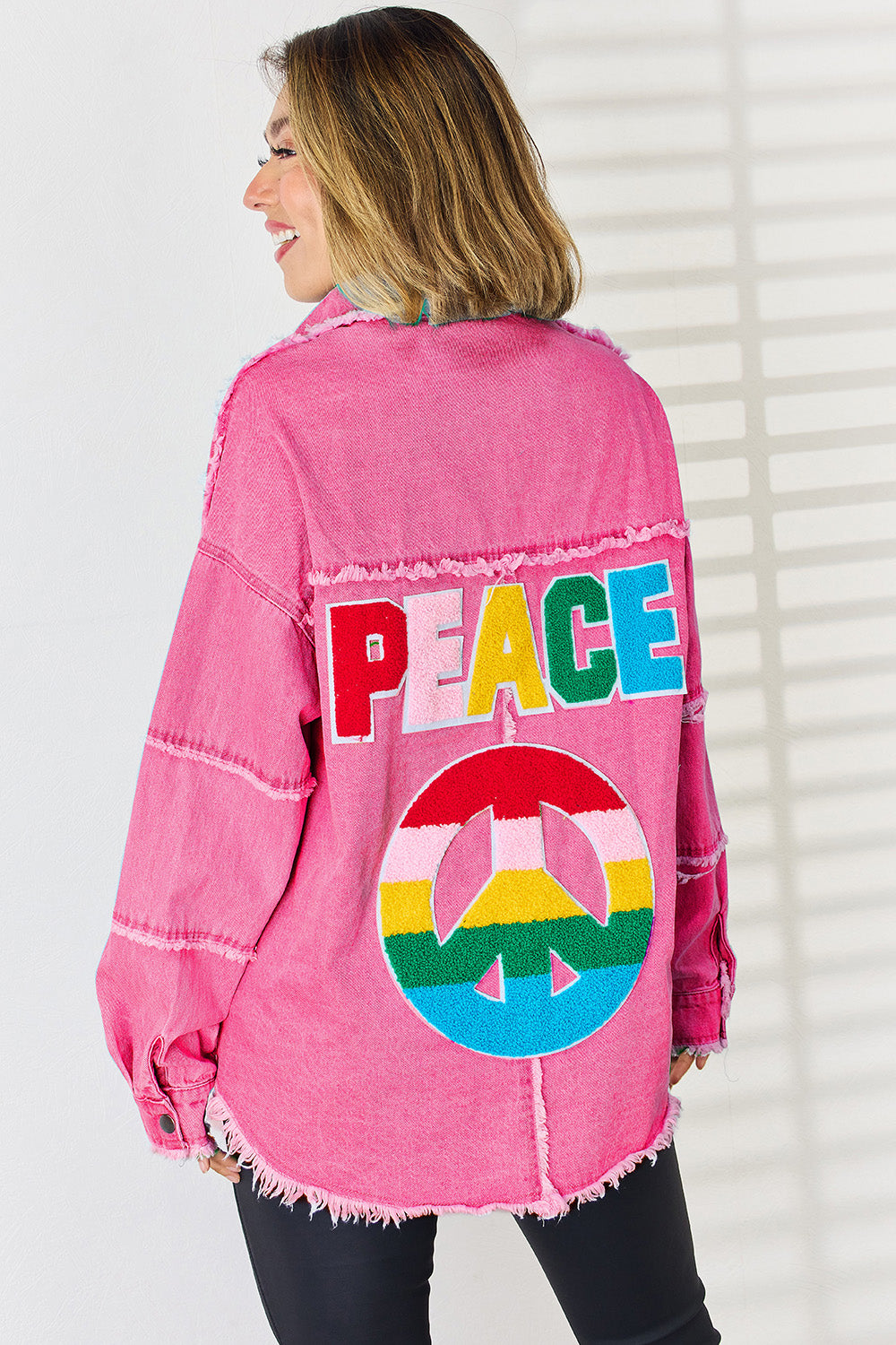 Hot pink denim overshirt with embroidered peace sign and lettering, frayed hem.