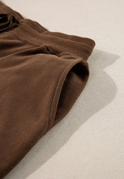 Brown relaxed fit lounge pants with elastic waistband and side pocket detail.