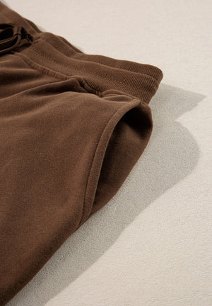 Brown relaxed fit lounge pants with elastic waistband and side pocket detail.
