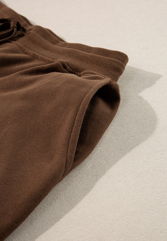 Brown relaxed fit lounge pants with elastic waistband and side pocket detail.