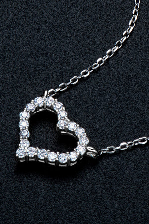 Silver heart pendant necklace with diamond embellishments on a delicate chain.