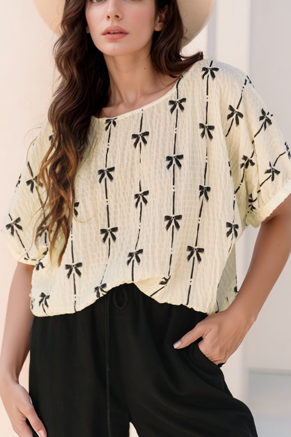 Beige gauze blouse with black bow print and gathered sleeves.