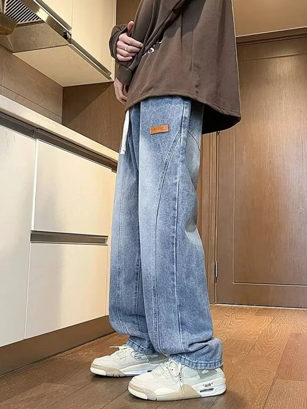 Men's blue vintage wash straight-leg jeans with drawstring and leather logo patch.