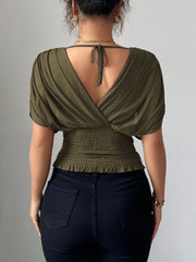 Army green ruched surplice dolman sleeve top with smocked waist and tie back detail.
